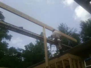 Carpenter setting a ridge beam over a new addition frame — Ice Dam Removal by Roofing Brothers in Gratz