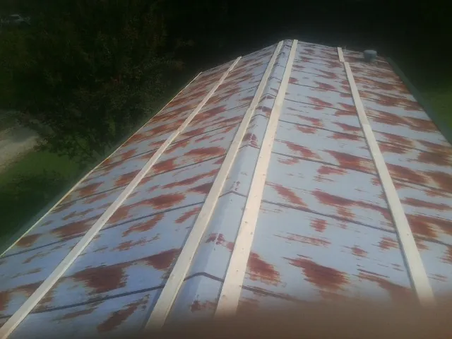 Rusted metal roof panels with new wood purlins before replacement — Storm Damage Roof Repair in Gratz by Roofing Brothers