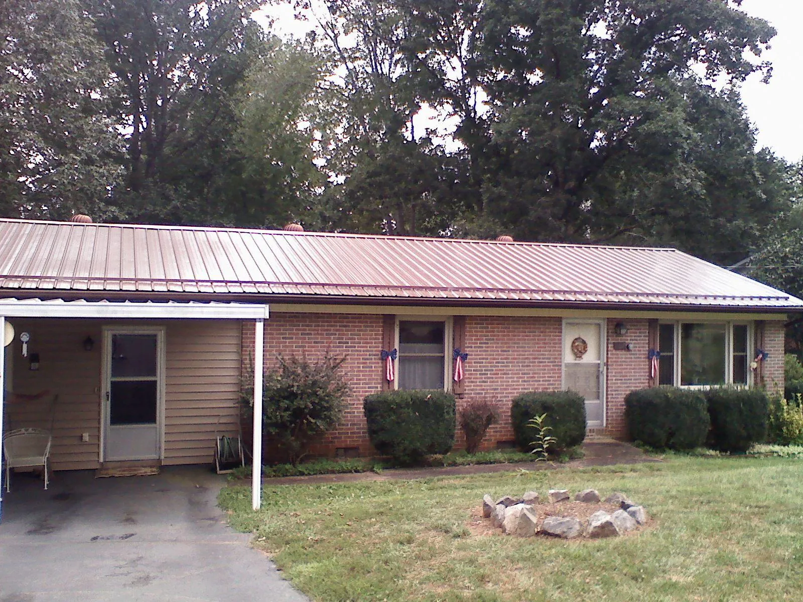 Bronze metal roof and carport on a brick ranch home — Roof Repair work by our crew in Gratz